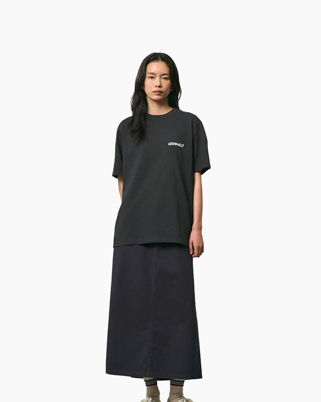 Gramicci Bass T-Shirt Vintage Schwarz, Modell Frontansicht mit schwarzem Rock, Gramicci-Logo linke Brust
